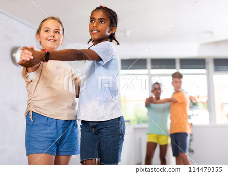 Active preteen children practicing Ballroom dances in pairs in training hall Active preteen children practicing Ballroom dances in pairs in training hall 114479355
