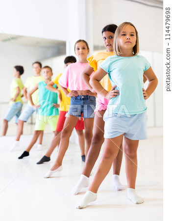 Children primary school age rehearsing movements of ballet dance in modern studio 114479698