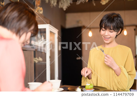 Two women eating cake in a cafe 114479709