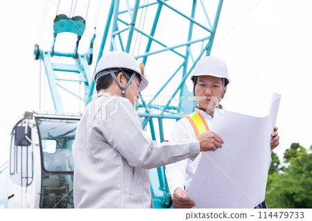 Workers working at a construction site 114479733