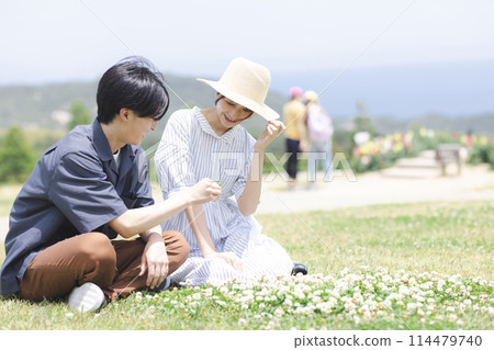 Young men and women relaxing on the grass Young men and women relaxing on the grass 114479740