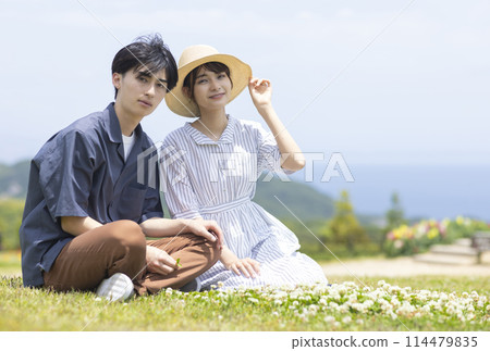 Young men and women relaxing on the grass Young men and women relaxing on the grass 114479835