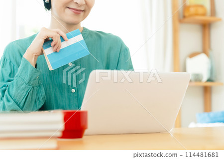Middle-aged woman checking her bankbook 114481681