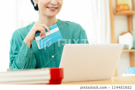 Middle-aged woman checking her bankbook 114481682