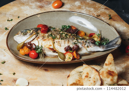 Seaside Sensation: Fresh Fish, Tomatoes, and Olives on Wooden Board 114482012