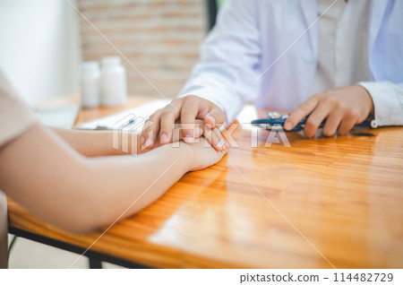 doctor hand holding the patient's hand. To encourage and comfort the patient so that the patient is not sad and worried. 114482729