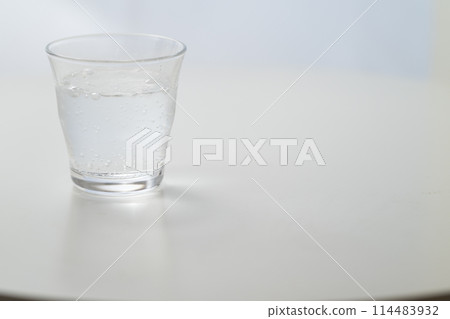 Glass of carbonated water by the window Glass of carbonated water by the window 114483932