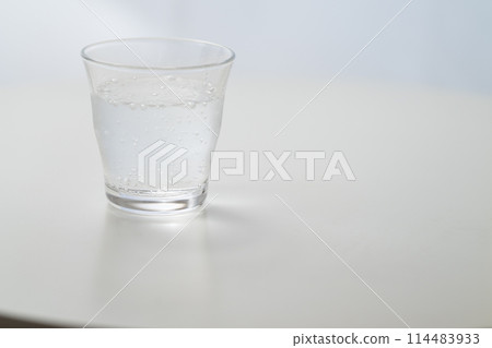 Glass of carbonated water by the window Glass of carbonated water by the window 114483933