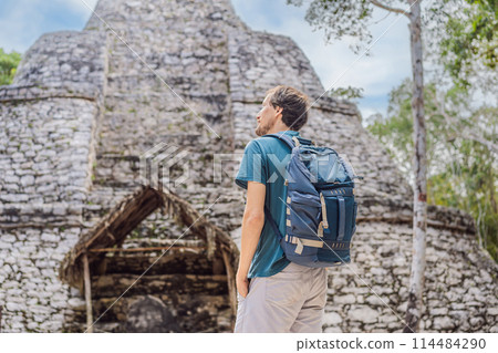 Man tourist at Coba, Mexico. Ancient mayan city in Mexico. Coba is an archaeological area and a famous landmark of Yucatan Peninsula. Cloudy sky over a pyramid in Mexico Man tourist at Coba, Mexico. Ancient mayan city in Mexico. Coba is an archaeological area and a famous landmark of Yucatan Peninsula. Cloudy sky over a pyramid in Mexico 114484290