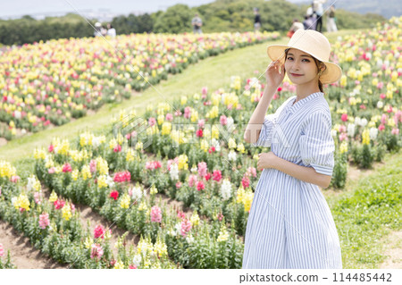 Young woman walking in flower garden 114485442