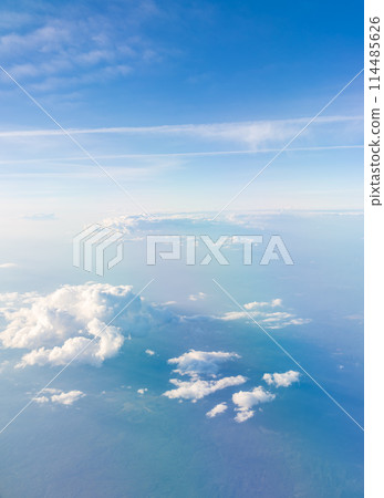 Aerial view from airplane window above green ground. View from the airplane window with beautiful clouds at sunrise 114485626