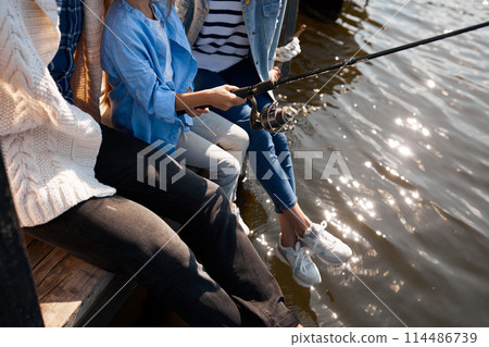 happy family with daughter fishing in pond in fall 114486739