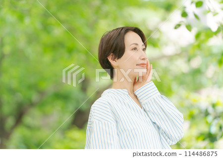 Beauty of a woman smiling among the fresh greenery 114486875