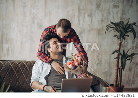 Romantic homo man presenting flowers to his beloved partner, Valentine's Day Romantic homo man presenting flowers to his beloved partner, Valentine's Day 114488651
