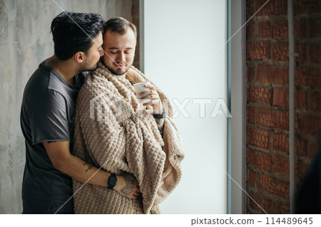 two handsome homosexual guys while standing near window 114489645