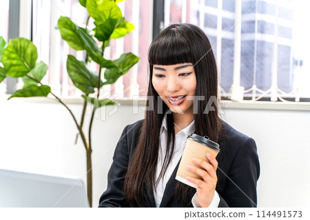 女僱員在喝咖啡時工作 女僱員在喝咖啡時工作 114491573