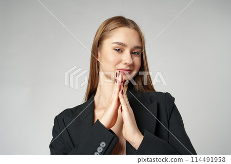 Young Woman in Black Jacket Posing to Camera against gray background 114491958