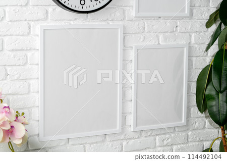 Minimalist White Wall Display With Clock and Empty Frames in a Modern Interior Minimalist White Wall Display With Clock and Empty Frames in a Modern Interior 114492104