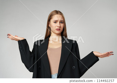 Clueless Young Woman Holding Out Her Hands Gesturing She Doesn't Know Clueless Young Woman Holding Out Her Hands Gesturing She Doesn't Know 114492257