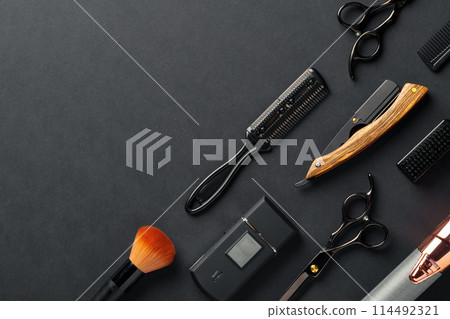 An Assortment of Professional Hairdressing Tools Laid Out on a Dark Surface An Assortment of Professional Hairdressing Tools Laid Out on a Dark Surface 114492321
