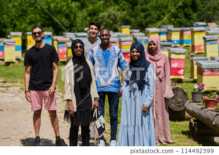 A diverse group of young friends and entrepreneurs explore small honey production businesses in the natural setting of the countryside. 114492399