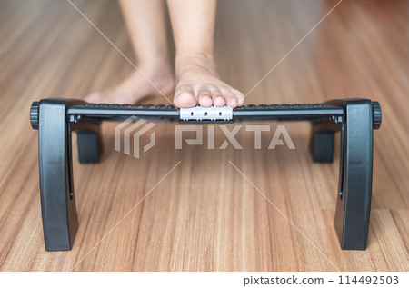 Woman massage with foot rest under desk for relieve plantar fasciitis at home 114492503