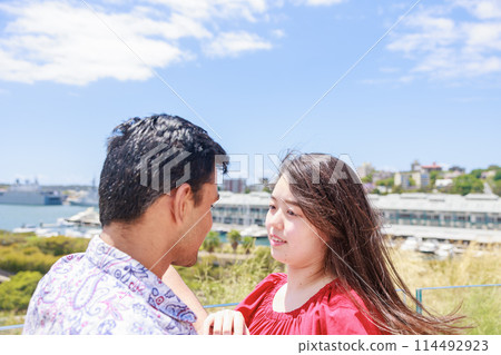 An international couple looking at each other under the blue sky An international couple looking at each other under the blue sky 114492923