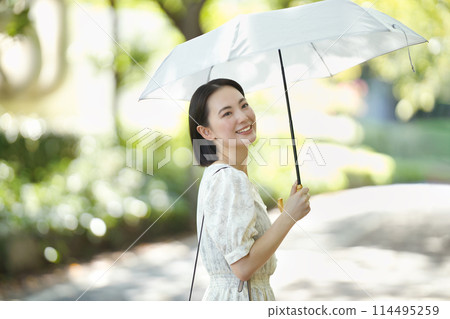 A young woman holding a parasol A young woman holding a parasol 114495259