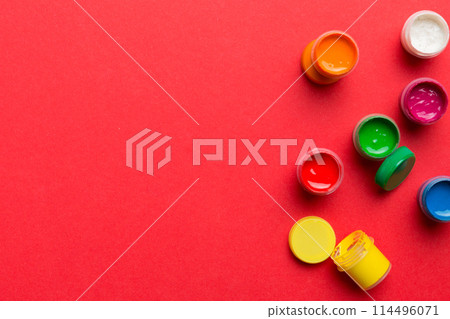 jars with gouache of different colors on Colored background. hobby painting. Top view with empty space. workplace for creativity. home teaching concept drawing jars with gouache of different colors on Colored background. hobby painting. Top view with empty space. workplace for creativity. home teaching concept drawing 114496071
