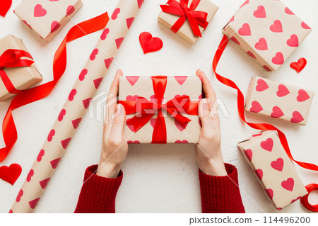 Give a gift on Valentine Day.Valentine gift. Beauty Woman hands holding Gift box with red bow over holiday background Give a gift on Valentine Day.Valentine gift. Beauty Woman hands holding Gift box with red bow over holiday background 114496200