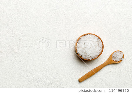 A wooden bowl of salt crystals on a wooden background. Salt in rustic bowls, top view with copy space A wooden bowl of salt crystals on a wooden background. Salt in rustic bowls, top view with copy space 114496550