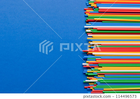 Heap of colorful plastic drinking straws on Colored background, flat lay. Copy Space for text 114496573