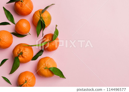 Many fresh ripe mandarin with green leaves on colored background, top view, space for text 114496577