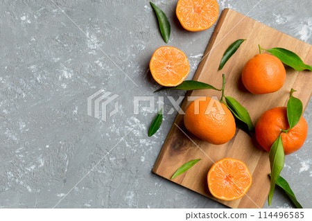 Many fresh ripe mandarin with green leaves on colored background, top view, space for text Many fresh ripe mandarin with green leaves on colored background, top view, space for text 114496585