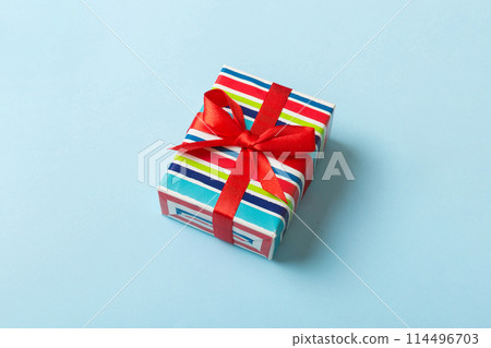 Wrapped christmas or other holiday handmade present in paper with colored ribbon. Present box, decoration of gift on table, top view with copy space 114496703
