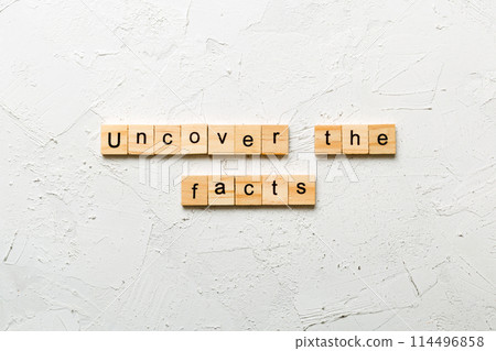 uncover the fact word written on wood block. uncover the fact text on table, concept 114496858