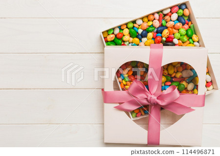 Box with sweet chocolate candies on color background, Various candy sweets. Valentines day gift box. Top view flat lay with copy space 114496871