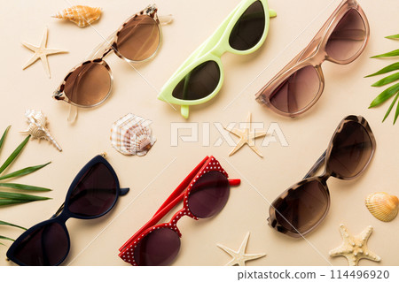 sunglasses with seashell lying on table background. Sunglasses on summer background. Top view flat lay with copy space for text 114496920