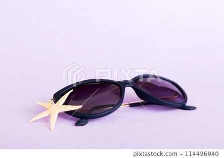 sunglasses with seashell lying on table background. Sunglasses on summer background. Top view flat lay with copy space for text 114496940