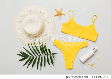 Woman swimwear and beach accessories flat lay top view. Top view with bikini outfit on color background. Vacation concept copy space Woman swimwear and beach accessories flat lay top view. Top view with bikini outfit on color background. Vacation concept copy space 114497067