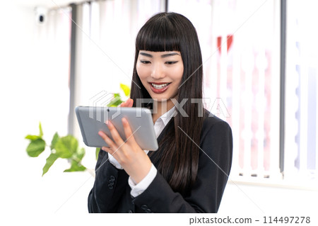 Female employees using tablets Female employees using tablets 114497278