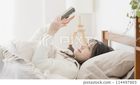 亞洲女性起床後看智慧型手機 114497803