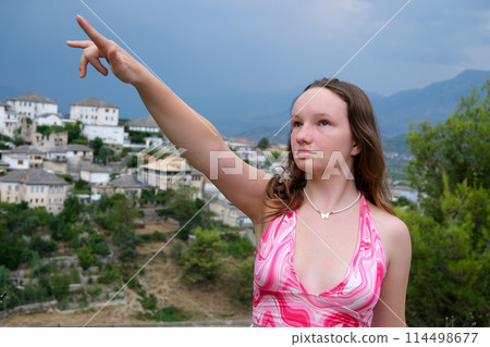 Young girl traveling in Albania attractions beauty nature. Gjirokastra attractions of Albania. Traveling to Albania watching the sights surprised young woman delighted with what is happening around Young girl traveling in Albania attractions beauty nature. Gjirokastra attractions of Albania. Traveling to Albania watching the sights surprised young woman delighted with what is happening around 114498677