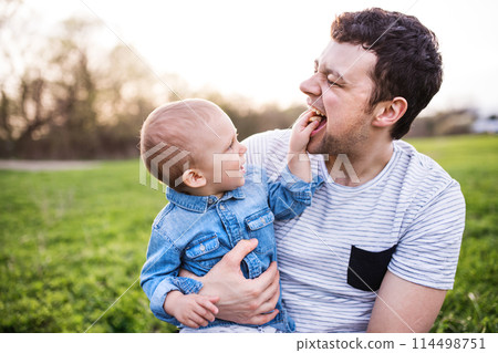 Father holding little toddler boy playing, having fun during warm spring day. Father's day concept. Father holding little toddler boy playing, having fun during warm spring day. Father's day concept. 114498751