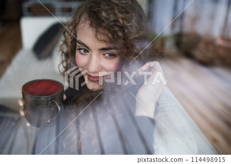 Morning routine for beautiful woman with curly hair drinking cup of coffee. Morning routine for beautiful woman with curly hair drinking cup of coffee. 114498915