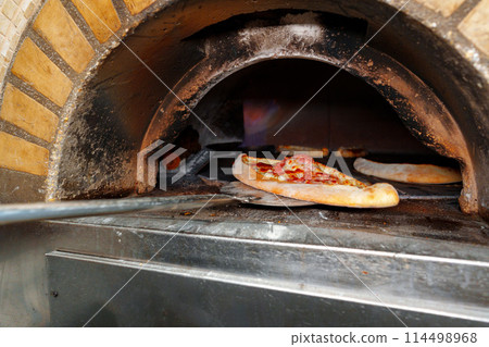 Pizza Cooking in Brick Oven Pizza Cooking in Brick Oven 114498968