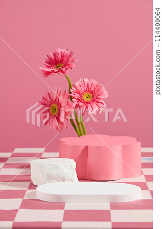 Creative design template of gerbera flower theme in pink tones, white blank tray placed in front with an empty flower shaped pedestal in back. Copy space for text, front view Creative design template of gerbera flower theme in pink tones, white blank tray placed in front with an empty flower shaped pedestal in back. Copy space for text, front view 114499064