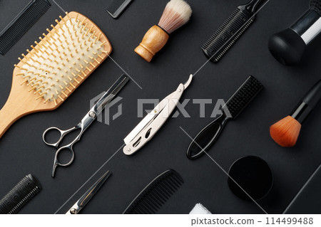 Variety of Hair Styling Tools and Accessories Displayed on a Dark Background 114499488