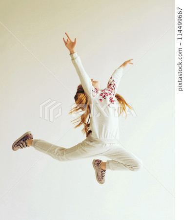 Beautiful gymnast girl in grey sportswear, performing art gymnastics element, jumping, doing split leap in the air Beautiful gymnast girl in grey sportswear, performing art gymnastics element, jumping, doing split leap in the air 114499667