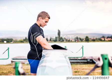 Young canoeist taking care of his canoe and paddle, cleaning, drying. Concept of canoeing as dynamic and adventurous sport 114499847